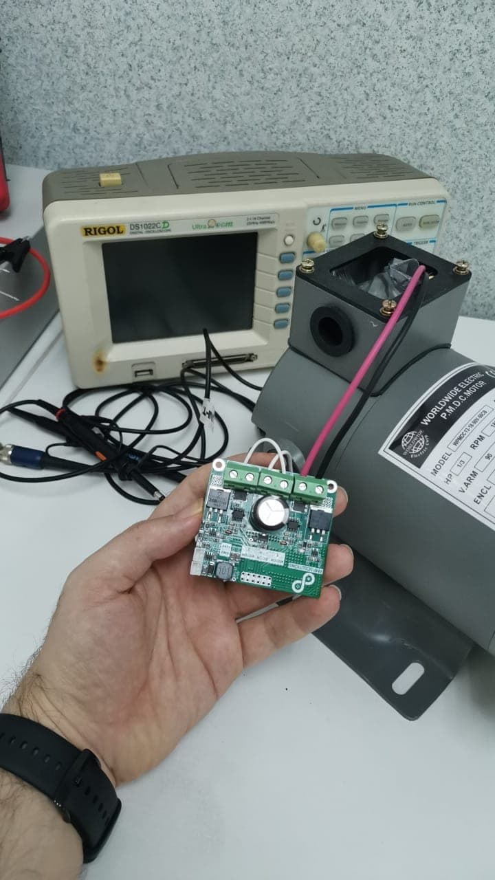 Motor driver board under test with an oscilloscope and a DC motor on the bench