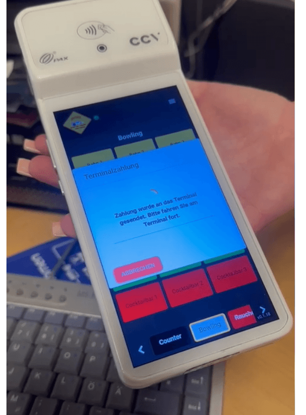 Handheld card payment terminal running the TigerHx app with a payment prompt on screen